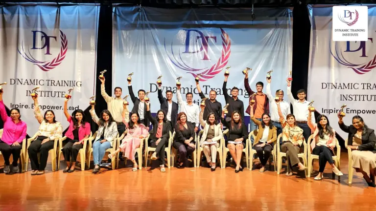 A Dynamic Training Institute batch on stage, raising their trophies