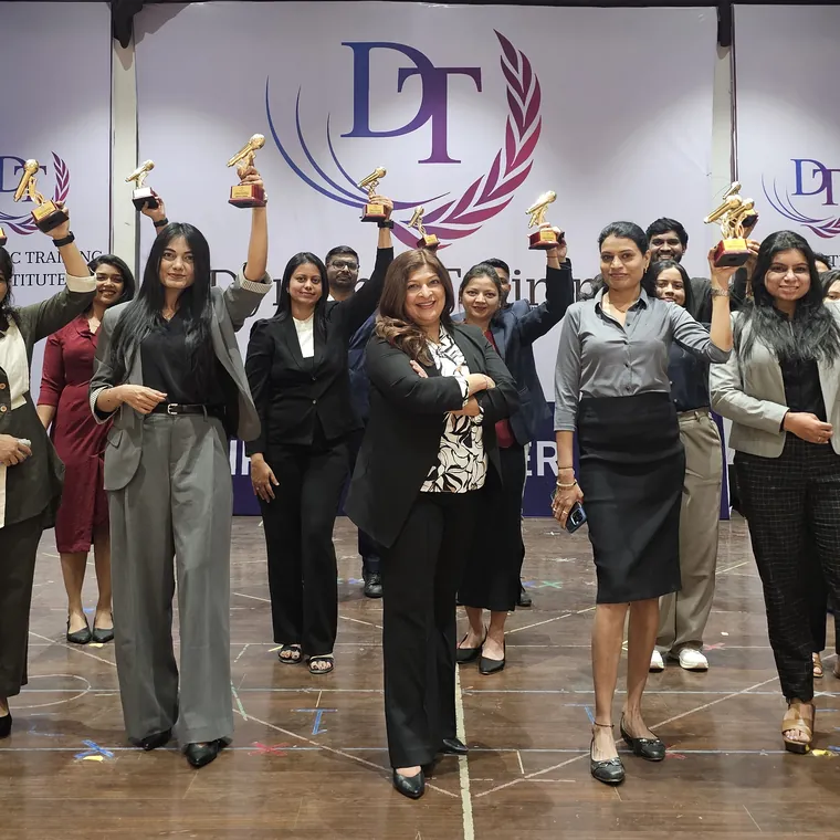 Dynamic Training Institute participants cheering with their trophies