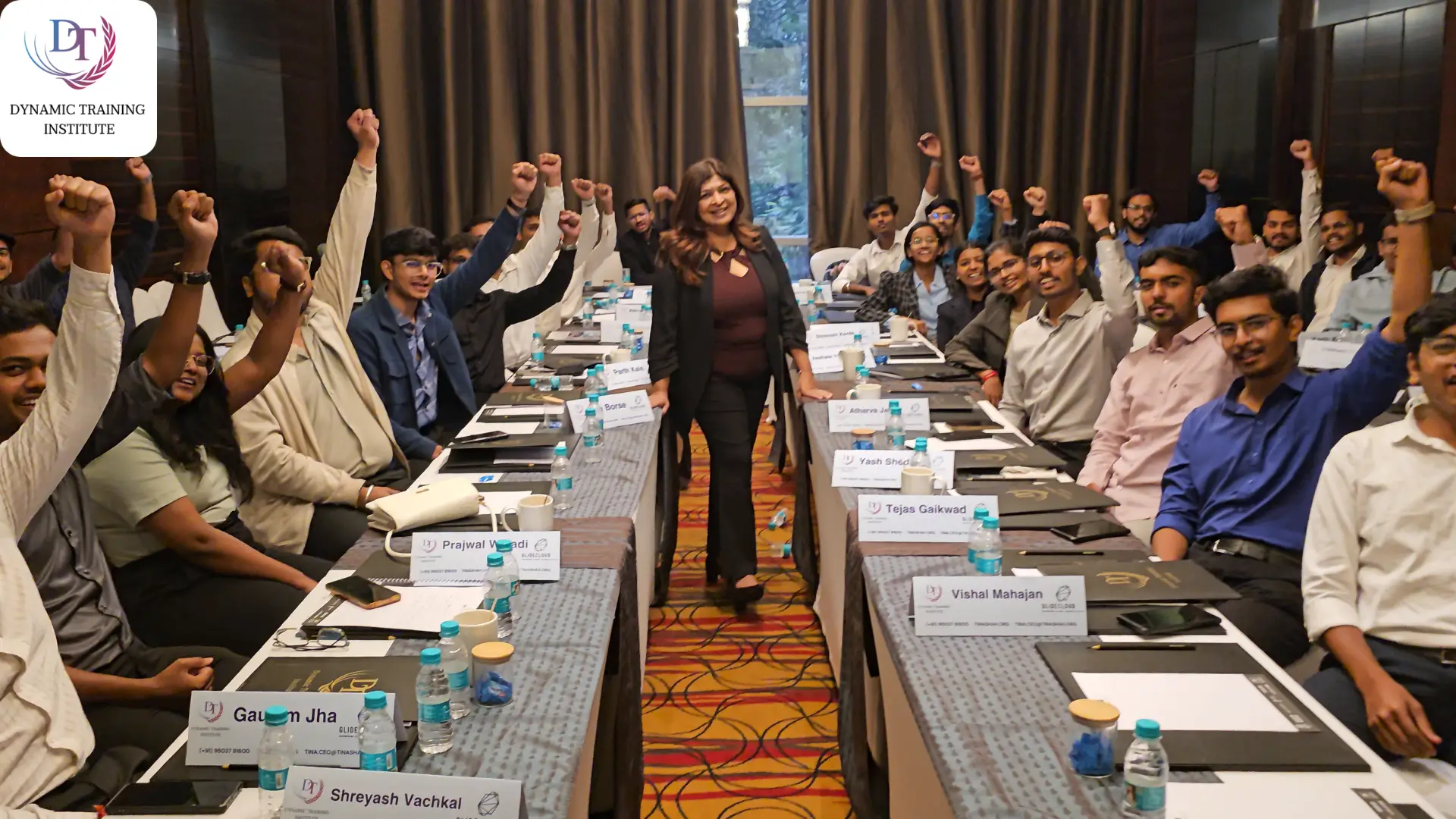 Tina Shah standing among cheering participants at a training session