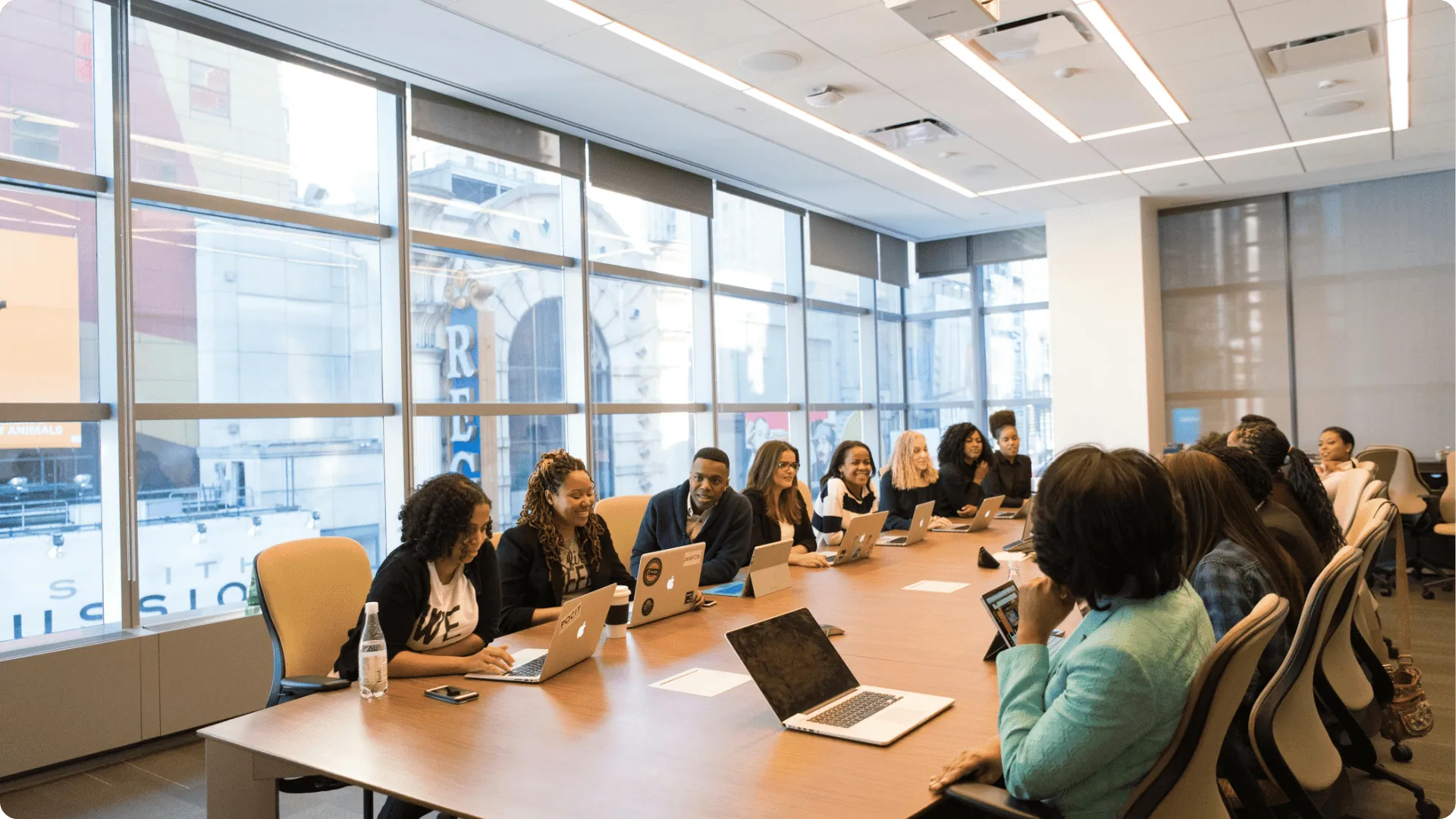 A team of professionals with laptops around a boardroom table