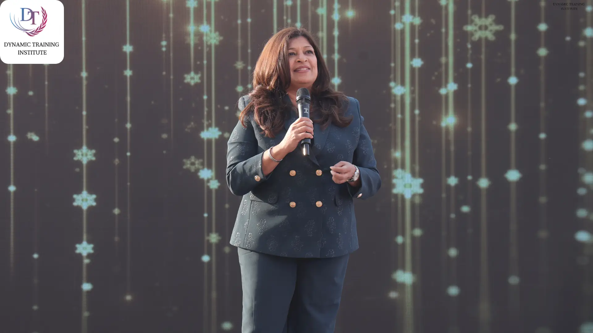 Tina Shah speaking on stage with a microphone