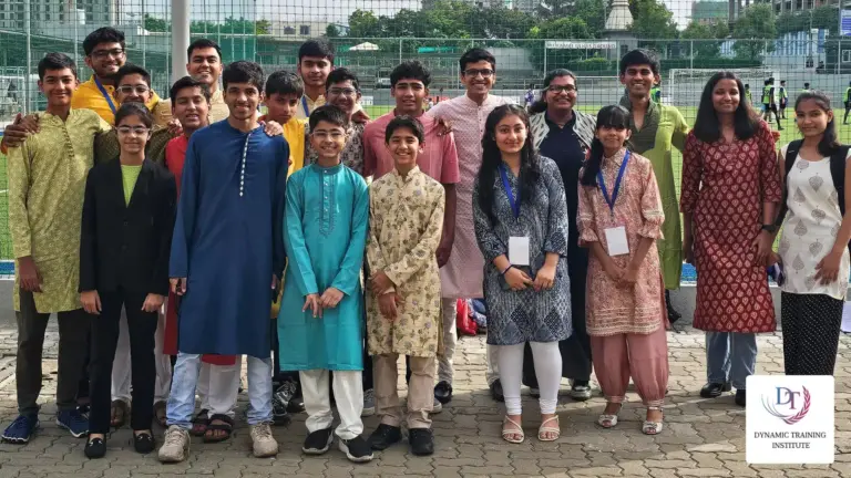 Students with conference badges, in festive Indian clothes, posing as a group outdoors