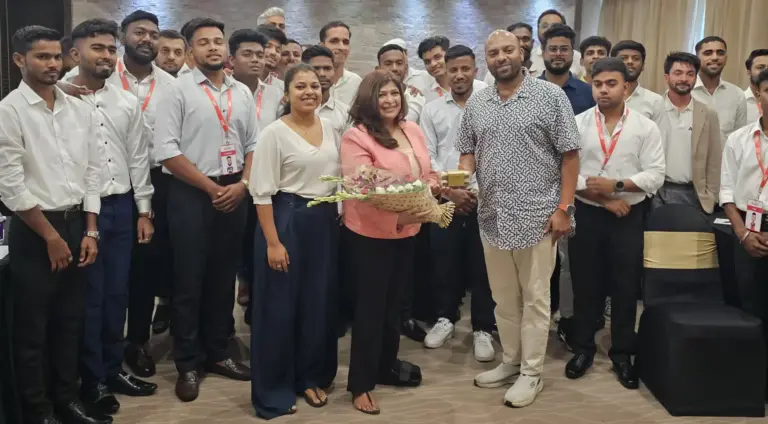 Tina Shah holding a bouquet of flowers with a corporate training batch at AtomX
