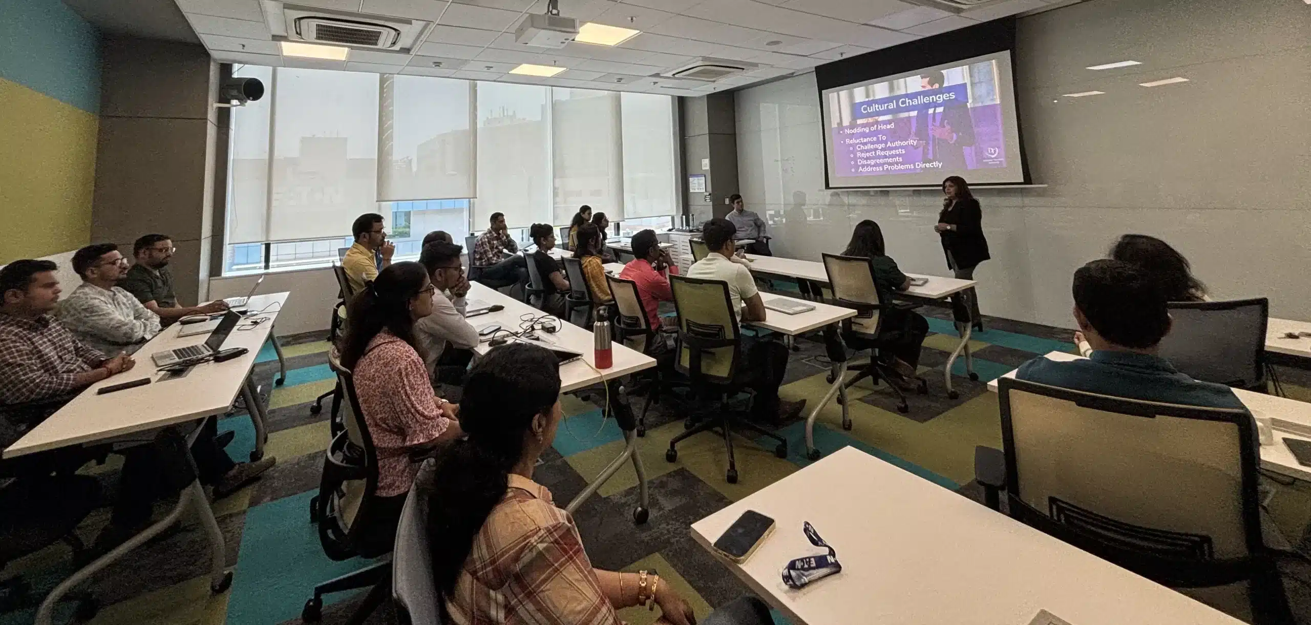 A corporate workshop at Eaton on cultural challenges, the trainer presenting beside the screen