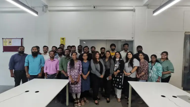 Group photo of a corporate training batch standing together in an office training room