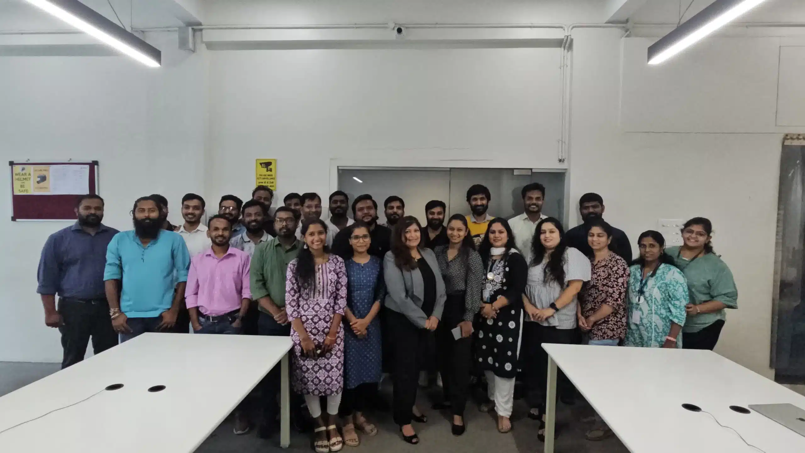 Group photo of a corporate training batch standing together in an office training room