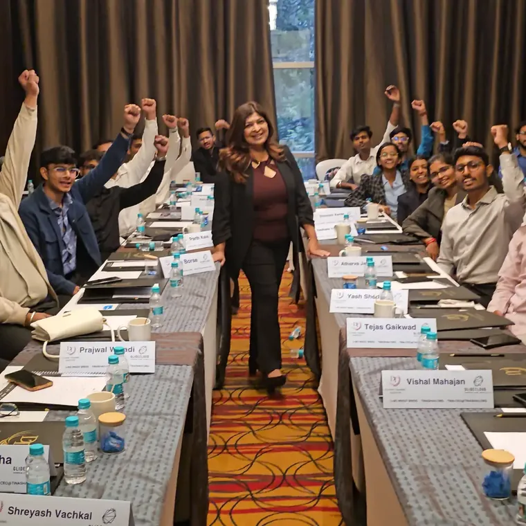 Tina Shah standing among cheering participants at a training session