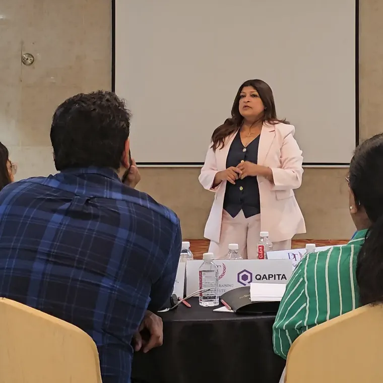 Tina Shah leading a training session for a seated group of professionals