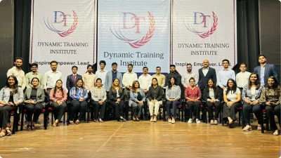 A large group of professionals in rows in front of three Dynamic Training Institute banners